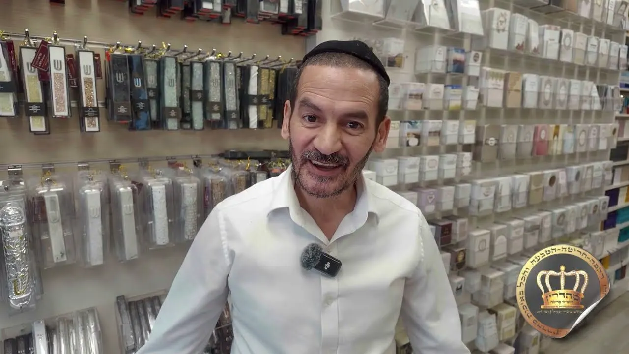 בעל חנות מסביר מול מדפי החנות